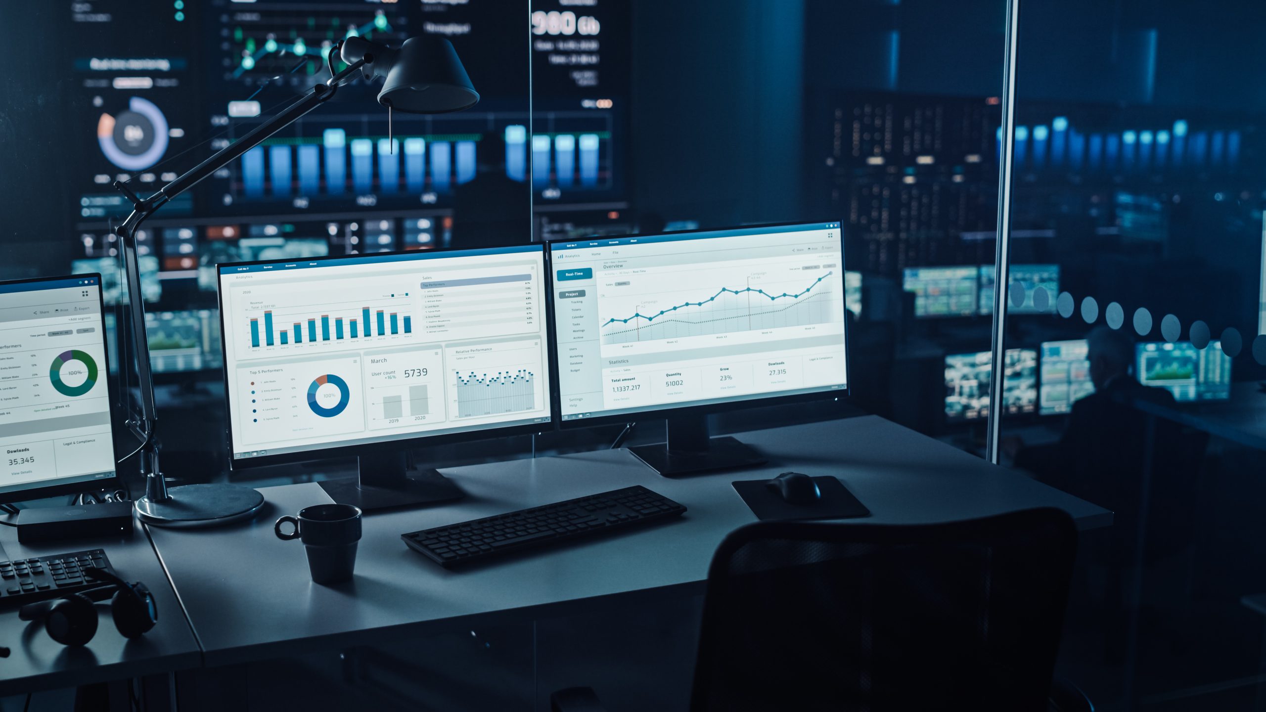 Two Digital Computer Screens with Financial Analytical Data in Modern Monitoring Office. Control Room with Finance Specialists Sit in Front of Computers.